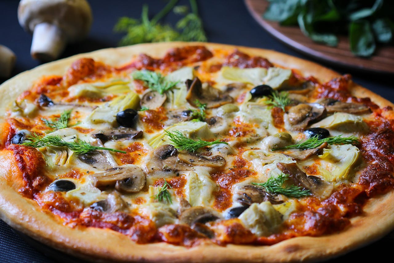 services-03 Close-up of a freshly baked vegetarian pizza with mushrooms, olives, and herbs perfect for food lovers.